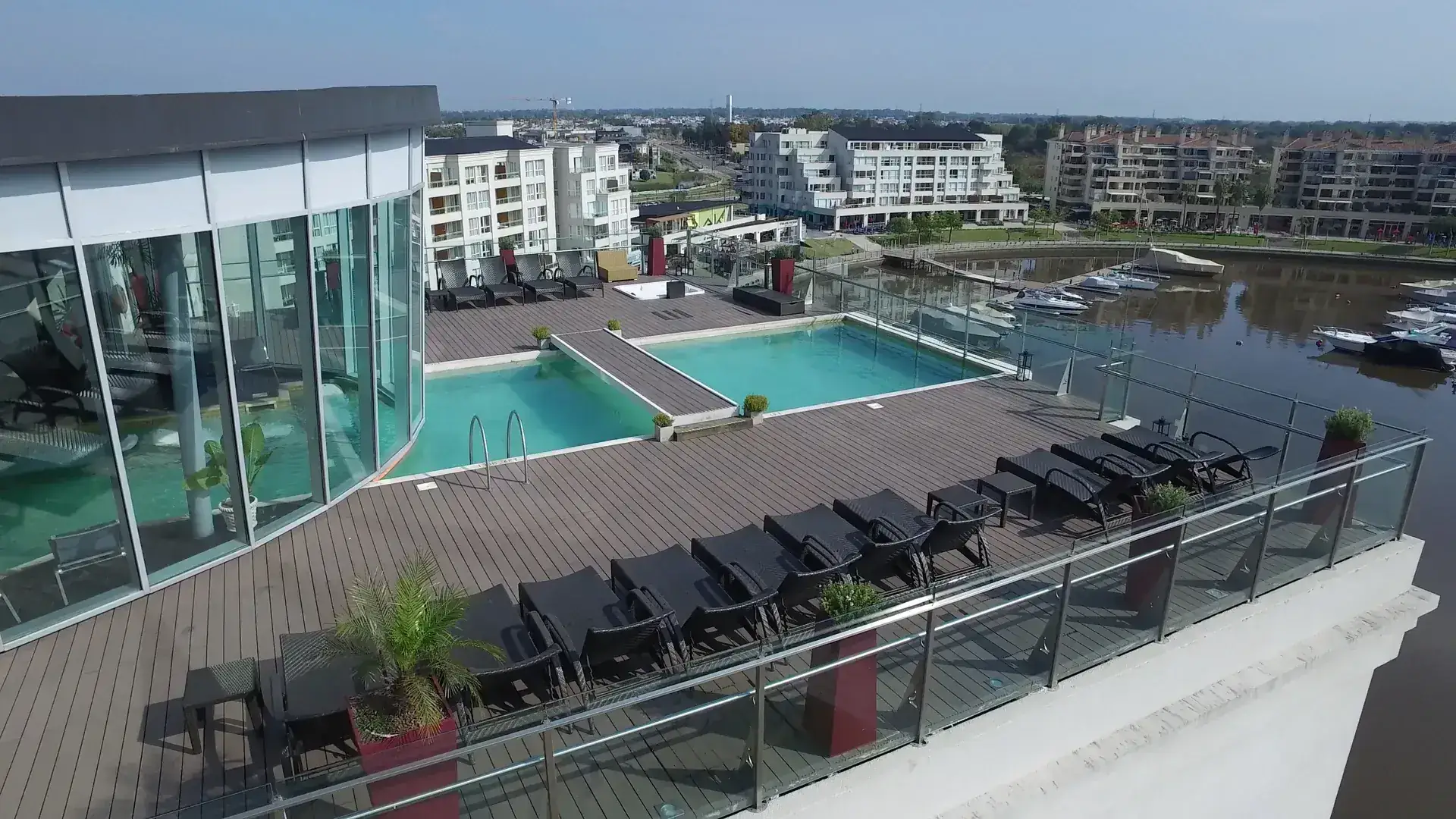 Vista aérea del rooftop de W Spa con sus piscinas y el puerto de la Bahía Grande